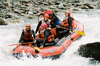 group of smiling folks going through rapids